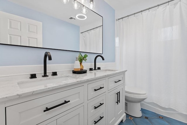 bathroom with double vanity, toilet, visible vents, and a sink