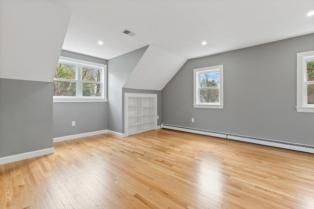 bonus room with light wood-style floors, visible vents, built in shelves, and a wealth of natural light