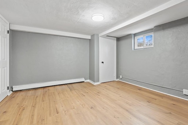 below grade area featuring baseboards, a baseboard radiator, and wood finished floors