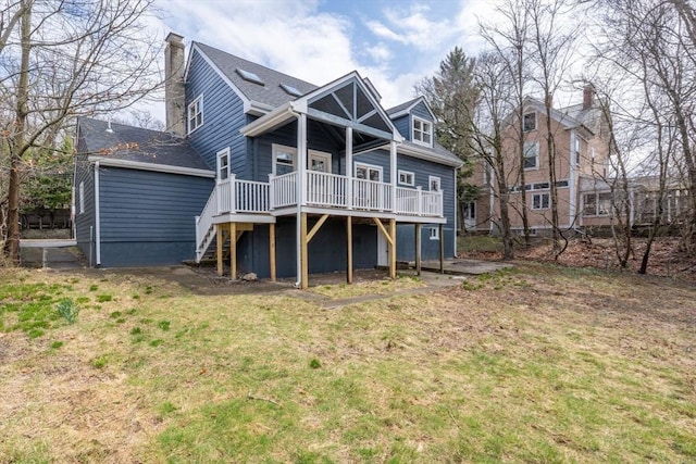 rear view of house with a lawn, a chimney, a wooden deck, and stairway