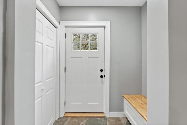 entryway with unfinished concrete floors and baseboards