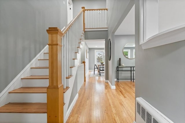 stairs with hardwood / wood-style flooring and a towering ceiling