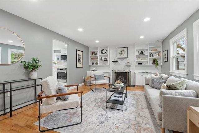living room featuring a healthy amount of sunlight, a fireplace, and recessed lighting