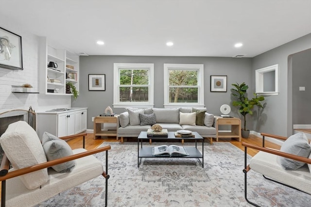 living area featuring light wood-style floors, baseboards, and recessed lighting