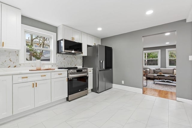 kitchen with appliances with stainless steel finishes, white cabinets, decorative backsplash, and recessed lighting