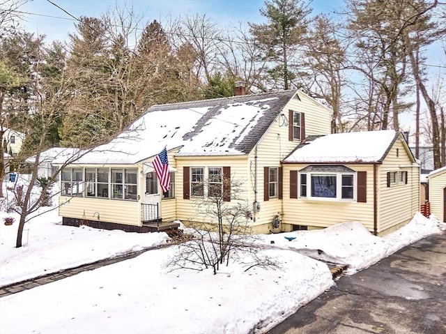 view of front of home featuring a sunroom and a chimney