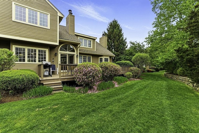 14 Weybridge Ln Unit 14, Hopkinton, MA 01748 - back of property featuring a chimney, a wooden deck, a yard, and a shingled roof