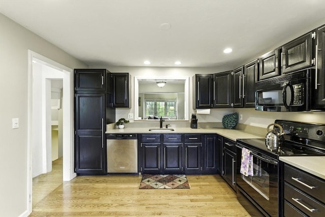 14 Weybridge Ln Unit 14, Hopkinton, MA 01748 - kitchen with black appliances, light countertops, a sink, light wood-style flooring, and dark cabinetry
