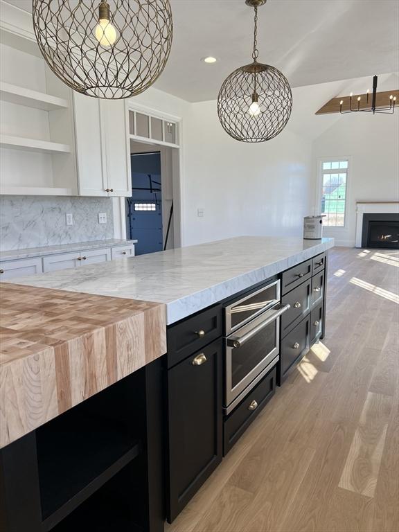 16 Clearview St, Grafton, MA 01536 - kitchen featuring dark cabinets, white cabinetry, light wood-style floors, open shelves, and open floor plan