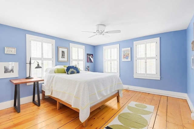 bedroom featuring light wood-style floors, baseboards, and a ceiling fan