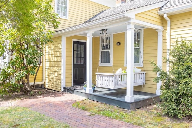 doorway to property with covered porch and a chimney