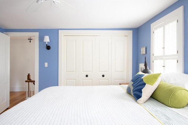 bedroom featuring ceiling fan, a closet, and wood finished floors