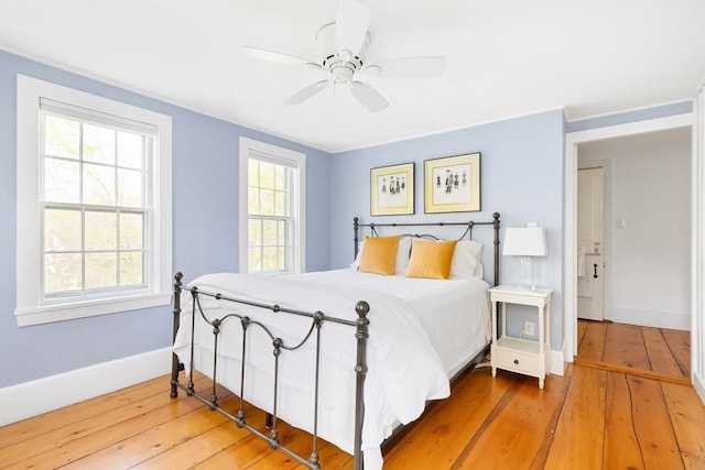 bedroom with baseboards, ceiling fan, and hardwood / wood-style floors