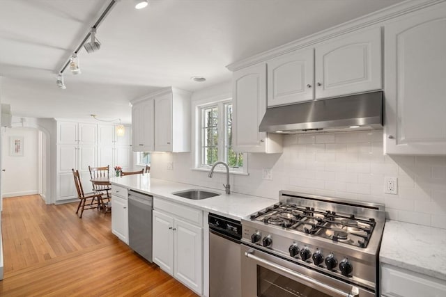 kitchen with a sink, appliances with stainless steel finishes, white cabinets, and under cabinet range hood
