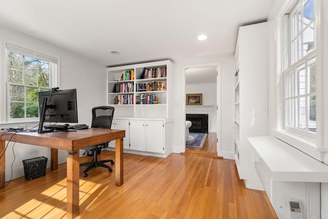 office area with a fireplace, recessed lighting, and light wood-type flooring