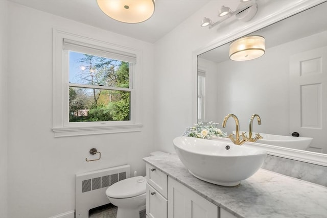 bathroom featuring radiator, baseboards, vanity, and toilet