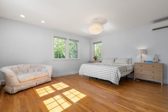 bedroom with light wood-style floors, a wall mounted air conditioner, baseboards, recessed lighting, and a chandelier