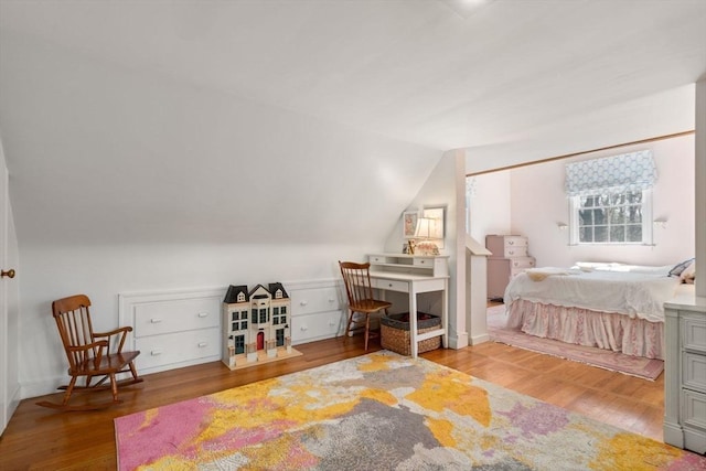 bedroom featuring wood finished floors and lofted ceiling