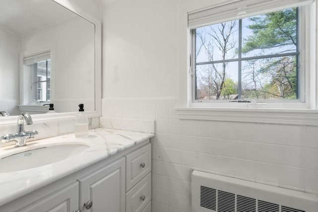 bathroom featuring heating unit and vanity