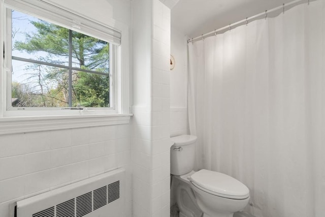 bathroom featuring toilet, a shower with curtain, tile walls, and radiator heating unit