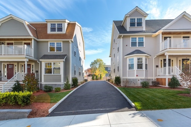 view of front of house featuring a balcony and a front yard