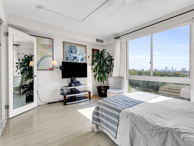 bedroom with light hardwood / wood-style floors and multiple windows