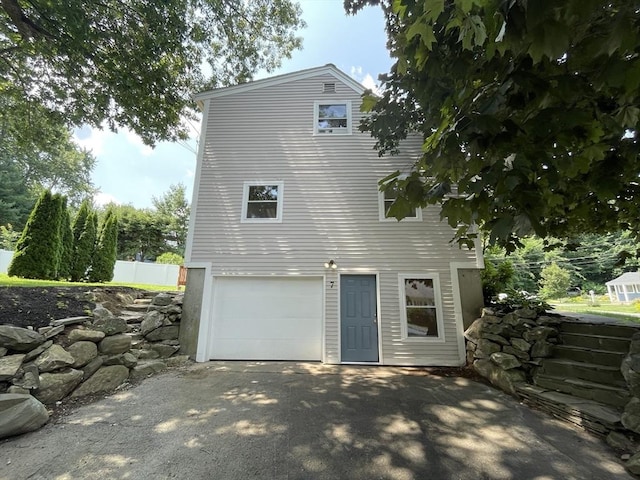 rear view of property with a garage and driveway