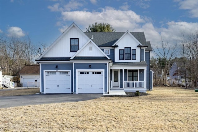 modern inspired farmhouse featuring board and batten siding, aphalt driveway, a front yard, roof with shingles, and covered porch