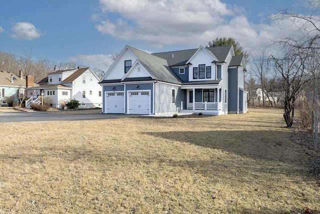 view of front facade featuring a residential view, driveway, covered porch, and a front lawn