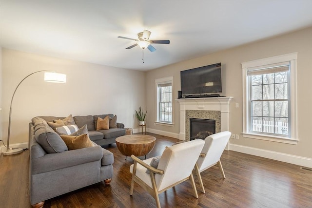 living room featuring dark wood-type flooring, a wealth of natural light, and ceiling fan