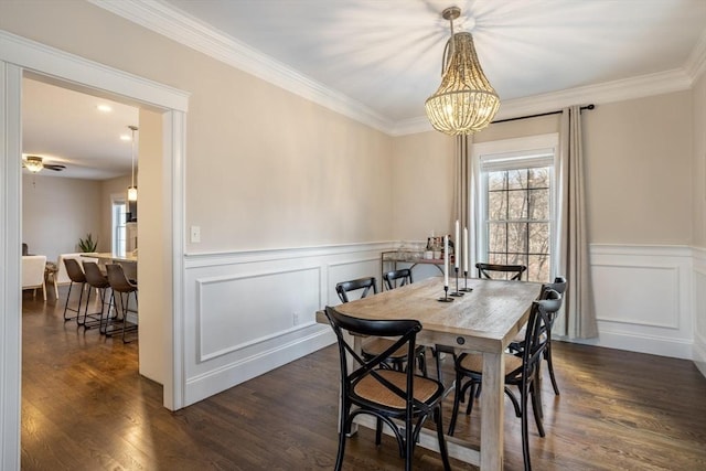 dining area with crown molding, dark hardwood / wood-style flooring, and ceiling fan with notable chandelier