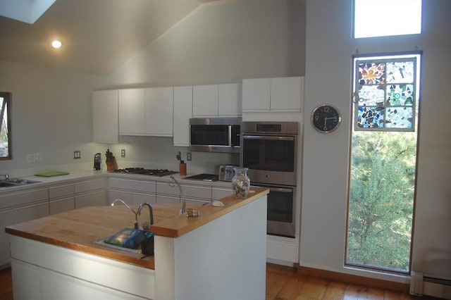 135 Marven Way, Wellfleet, MA 02667 - kitchen featuring appliances with stainless steel finishes, baseboard heating, light countertops, white cabinets, and high vaulted ceiling