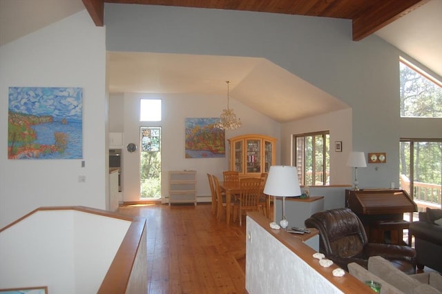 135 Marven Way, Wellfleet, MA 02667 - living area with high vaulted ceiling, beam ceiling, healthy amount of natural light, hardwood / wood-style flooring, and a chandelier