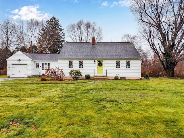 rear view of property featuring a garage and a lawn