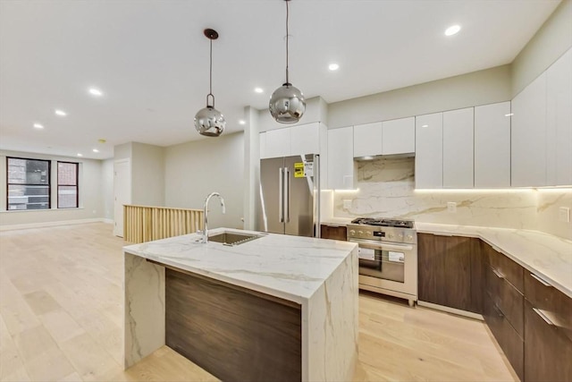 kitchen with stainless steel appliances, a sink, modern cabinets, recessed lighting, and decorative backsplash