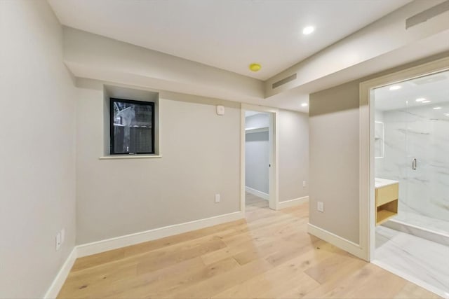 finished basement with light wood-style floors, recessed lighting, and baseboards