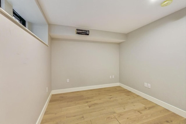 spare room featuring light wood-type flooring and baseboards