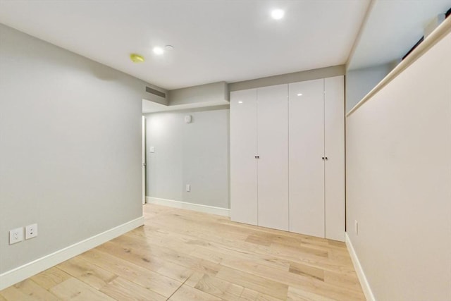 finished below grade area featuring light wood-style flooring, recessed lighting, and baseboards