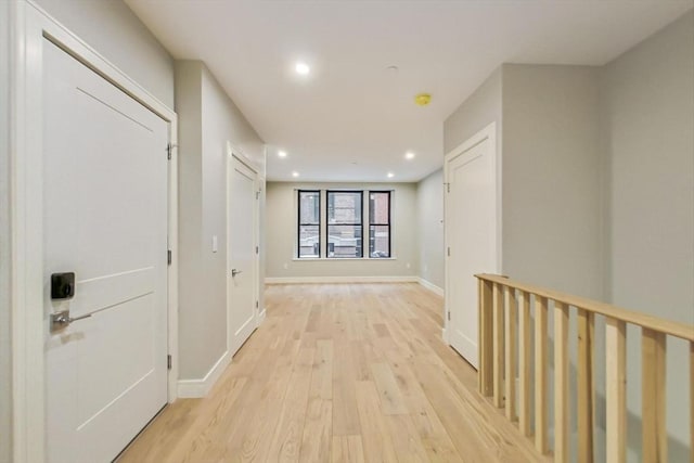 hallway with light wood-style floors, recessed lighting, and baseboards