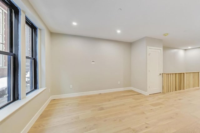 spare room featuring light wood-style floors, baseboards, and recessed lighting