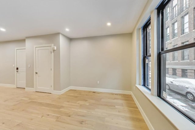 spare room featuring light wood-style flooring, baseboards, and recessed lighting