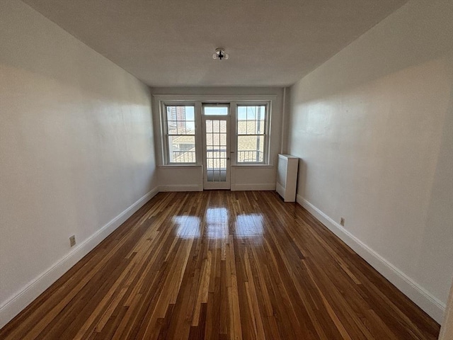 unfurnished room featuring dark wood finished floors and baseboards