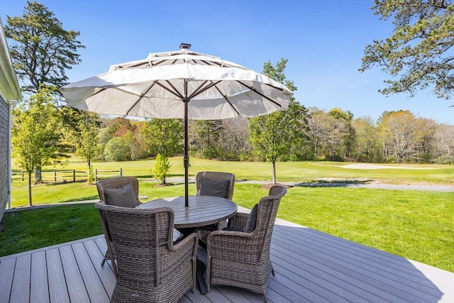 deck with outdoor dining space and view of scattered trees