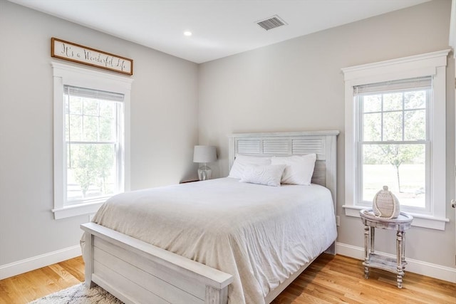 bedroom featuring multiple windows, wood finished floors, baseboards, and recessed lighting