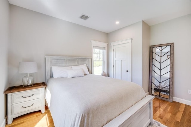 bedroom with light wood-type flooring, recessed lighting, and baseboards