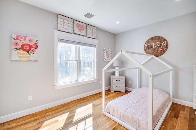 bedroom with wood finished floors, baseboards, and recessed lighting