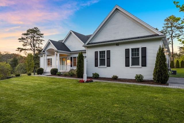 view of front of property featuring a lawn and central AC