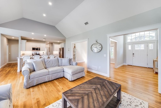 living area featuring lofted ceiling, light wood-style floors, recessed lighting, and baseboards