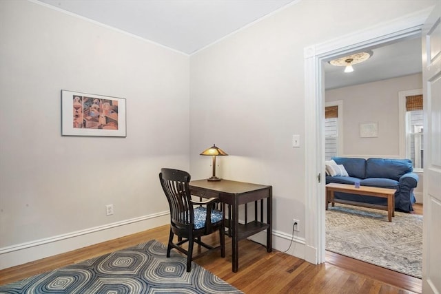 office featuring wood finished floors, crown molding, and baseboards