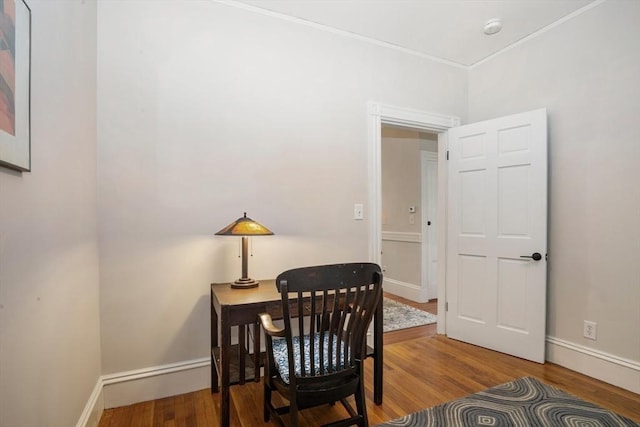office featuring wood finished floors, ornamental molding, and baseboards